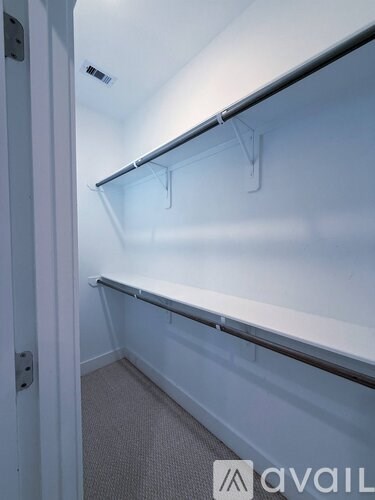 A white closet with shelves and hooks.