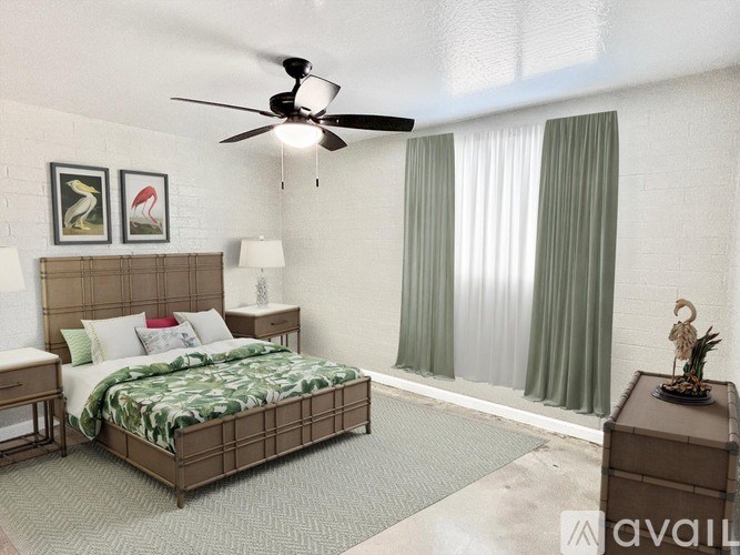 A bedroom with a large bed, a ceiling fan, and two framed pictures on the wall.
