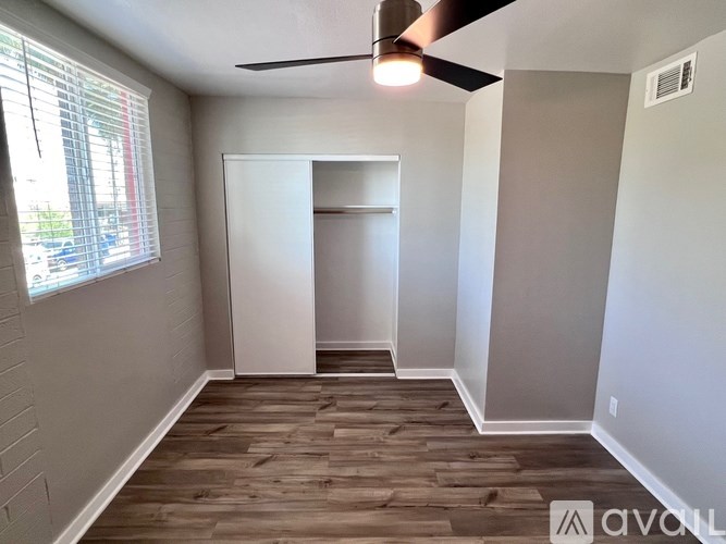 A room with a ceiling fan and wooden flooring.