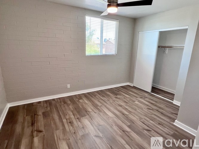 A room with wooden flooring and a ceiling fan.