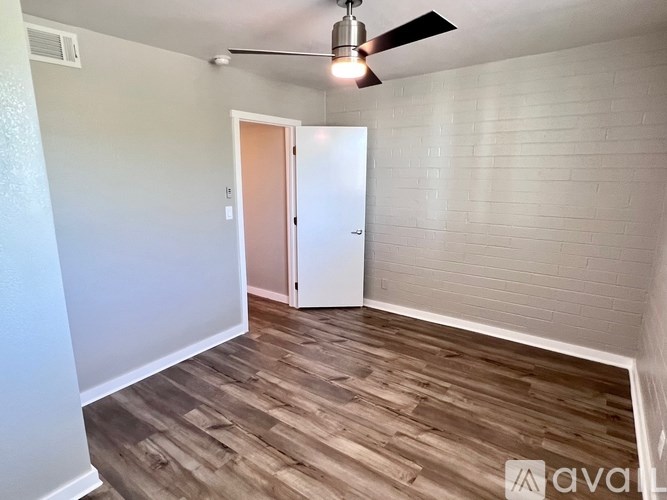 A room with a wooden floor and a ceiling fan.