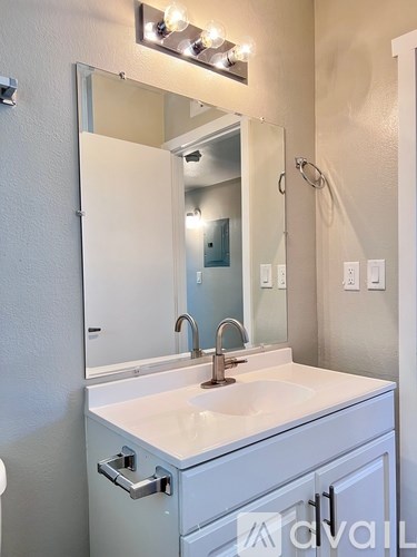A white bathroom vanity with a sink and mirror.