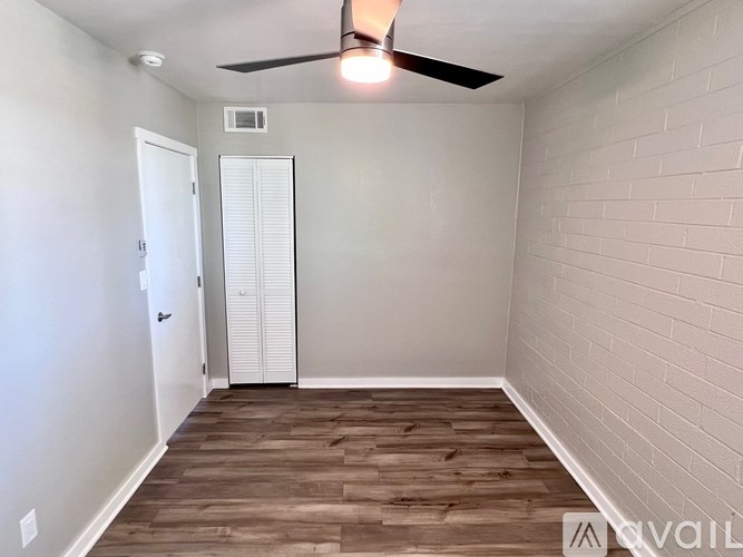 A room with a ceiling fan and wooden flooring.