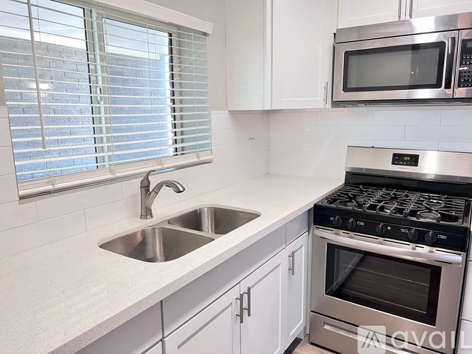 A modern kitchen with a stainless steel oven and white cabinets.