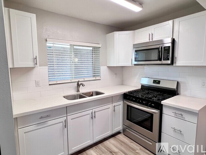 A kitchen with white cabinets and a stainless steel oven.