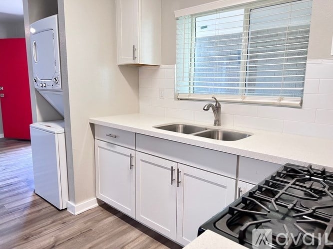 A kitchen with white cabinets and a black stove top.