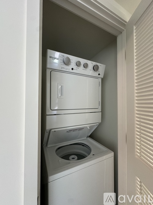A white Whirlpool dishwasher and washing machine are stacked in a small space.