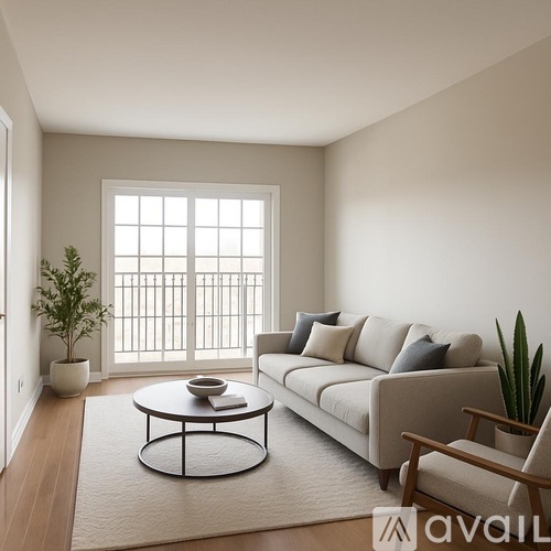 A living room with a white sofa, a round coffee table, and a potted plant.