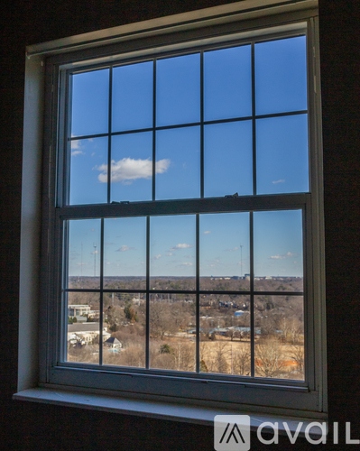 A window with a view of a town and trees.