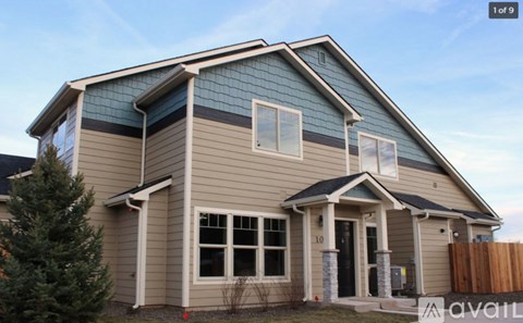 A house with a blue roof and a brown fence.