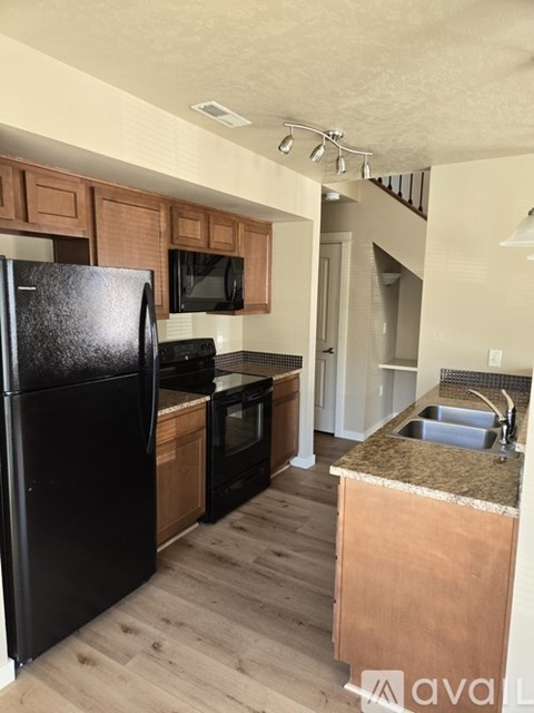 A kitchen with black appliances and wooden cabinets.