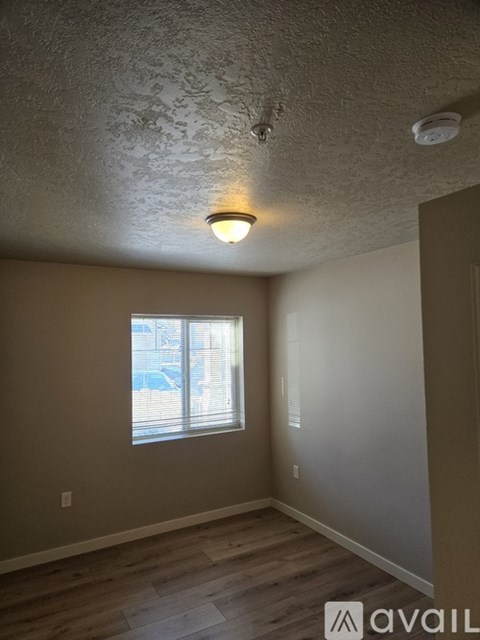 A room with a window and wooden flooring.