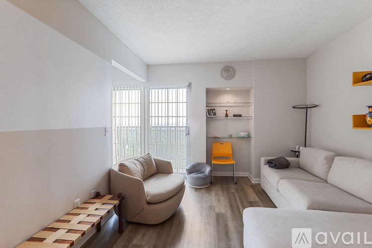 A living room with a white couch, a chair, and a small table.