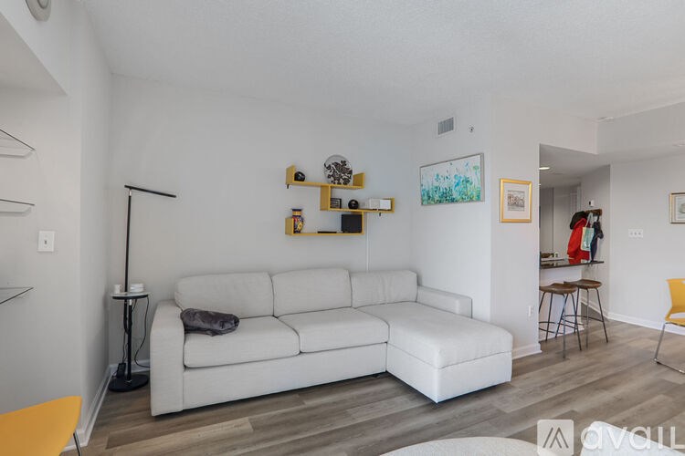 A living room with a white couch and a yellow chair.