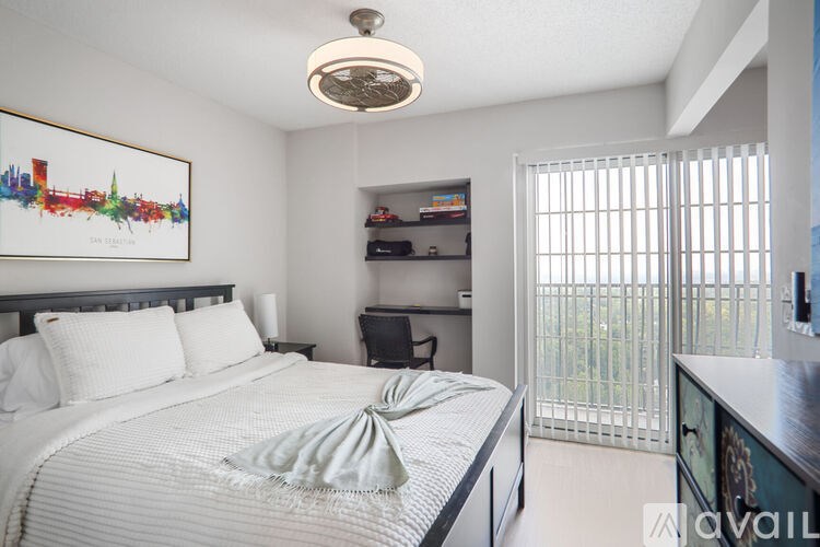 A bedroom with a large bed and a painting on the wall.