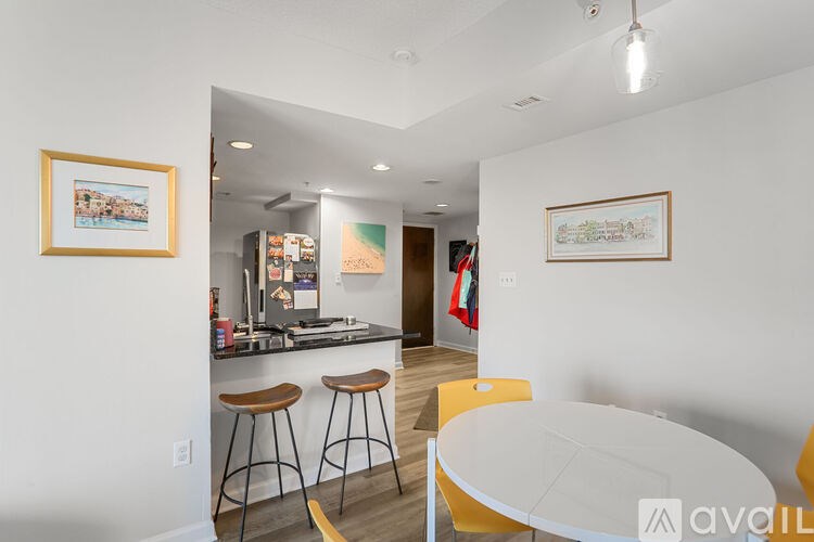 A kitchen with a bar stool and a framed picture on the wall.