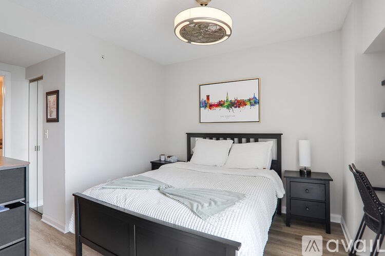 A bedroom with a bed, nightstand, and chair.