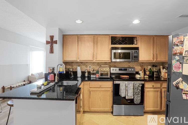 A kitchen with wooden cabinets and black countertops.