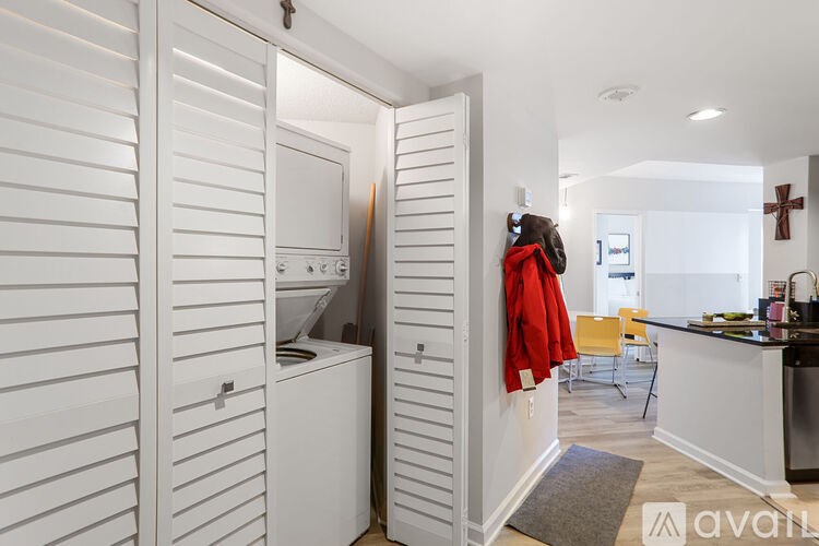 A red jacket is hanging on a white door.