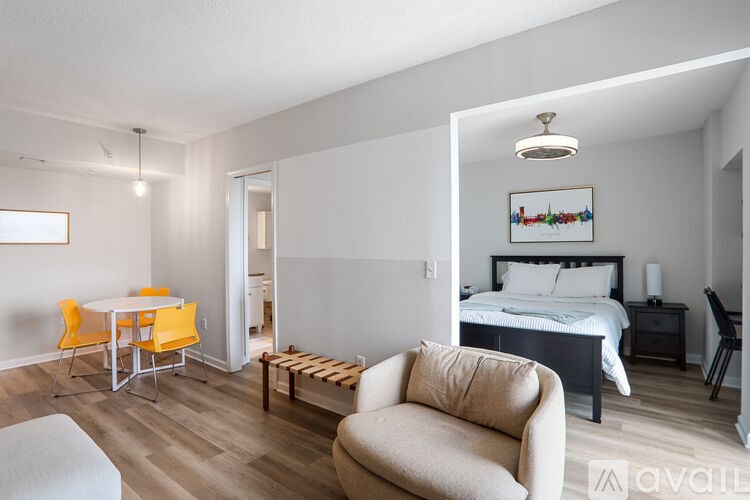 A bedroom with a bed, nightstand, and chair.