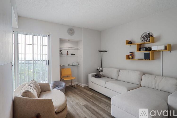 A living room with a white couch and a yellow chair.