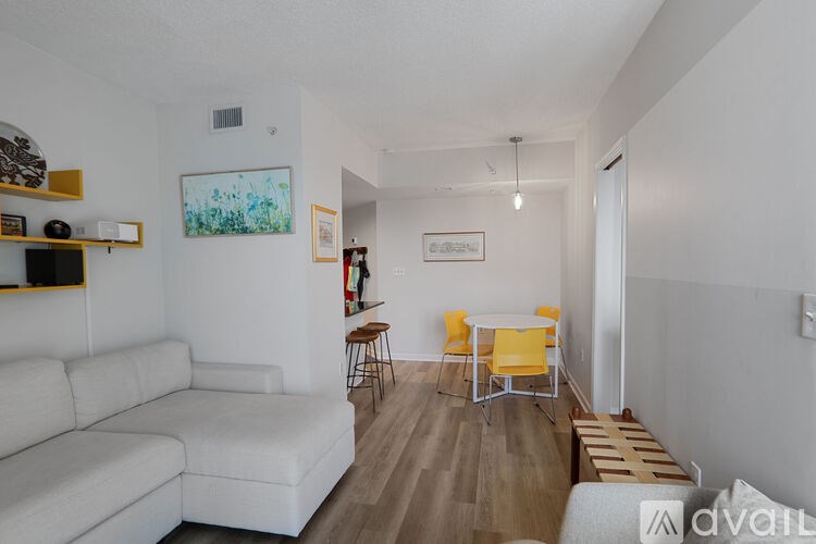 A living room with a white couch and yellow chairs.