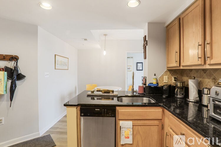 A kitchen with wooden cabinets and a black countertop.