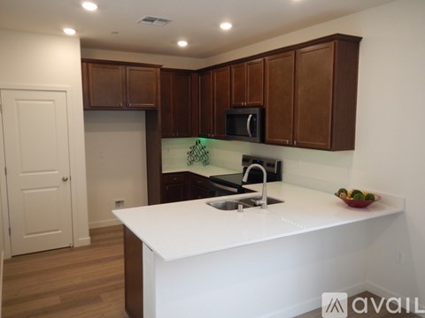 A kitchen with brown cabinets and a white counter.