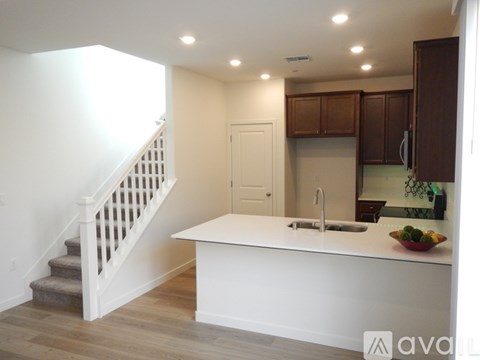 A kitchen with a white countertop and wooden cabinets.