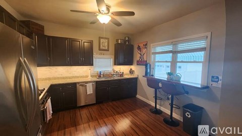 A kitchen with dark wood cabinets and a stainless steel refrigerator.