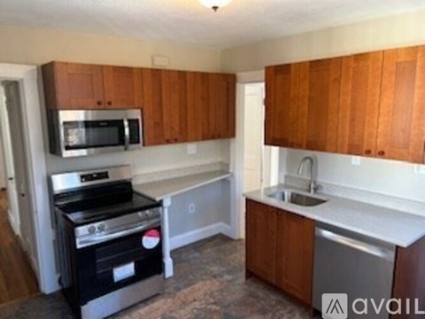 A kitchen with wooden cabinets and a stainless steel dishwasher.