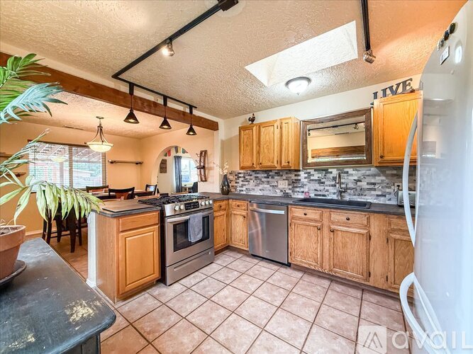 A kitchen with wooden cabinets and a tile floor.