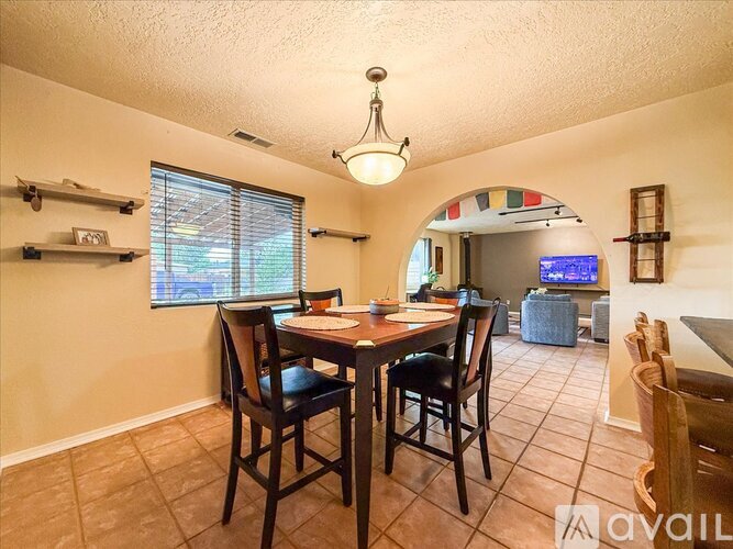 A dining room with a table and chairs.