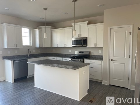 A kitchen with white cabinets and a granite countertop.