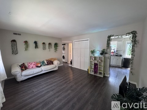 A living room with a white couch and a grey floor.