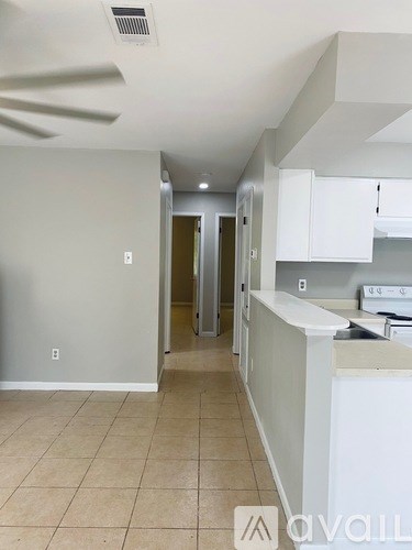 A kitchen with white cabinets and a tiled floor.