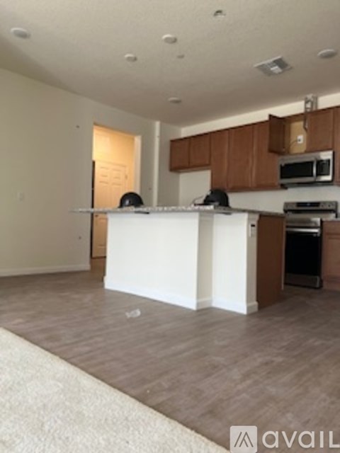 A kitchen with a white counter and brown cabinets.