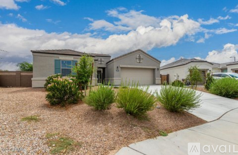 A house with a driveway and landscaping in front of it.