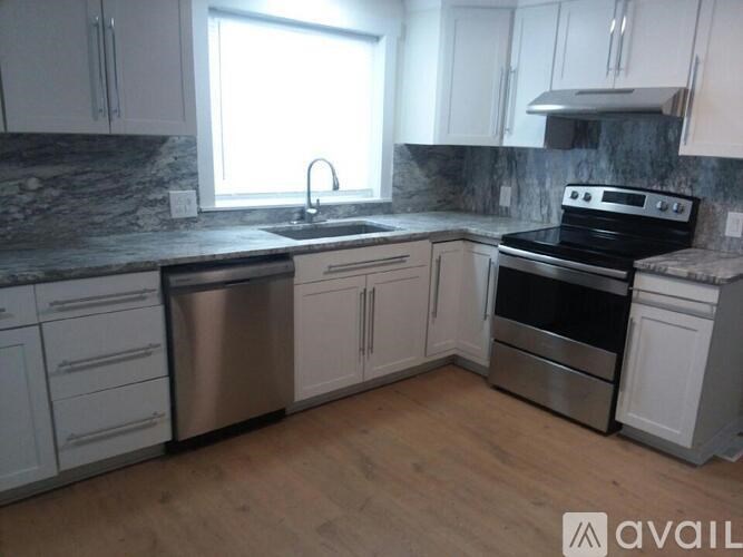 A kitchen with white cabinets and a black stove top oven.