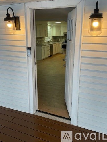 A white door with a glass window leading to a kitchen.