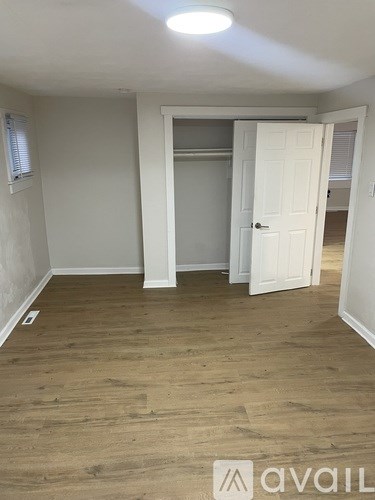 A room with wooden flooring and a white door.
