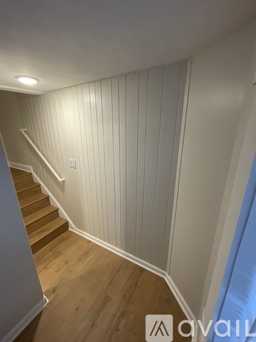 A staircase with wooden steps and white walls.