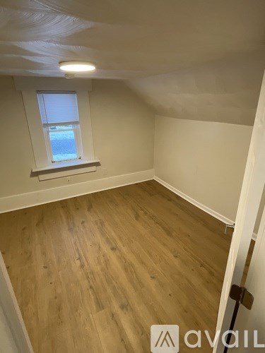 A room with wooden flooring and a window.