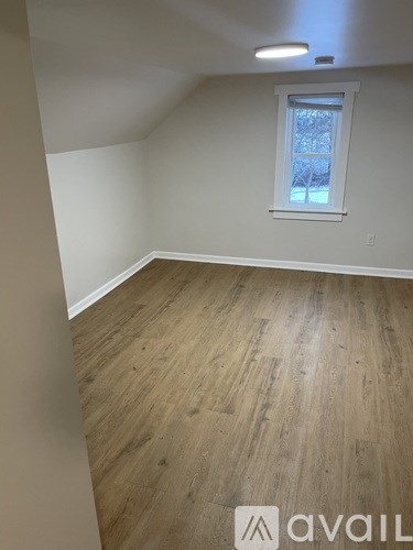 A room with wooden flooring and a window.