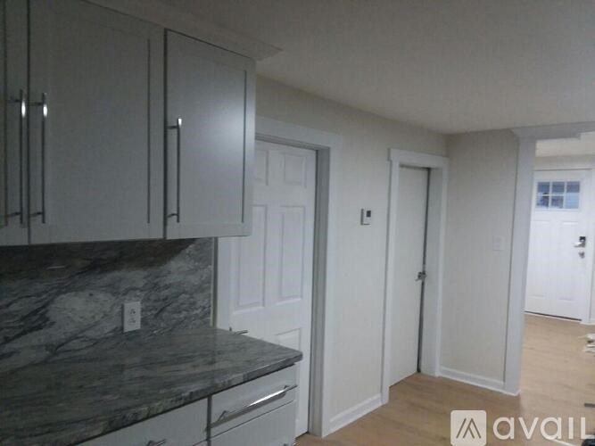 A kitchen with granite countertops and white cabinets.