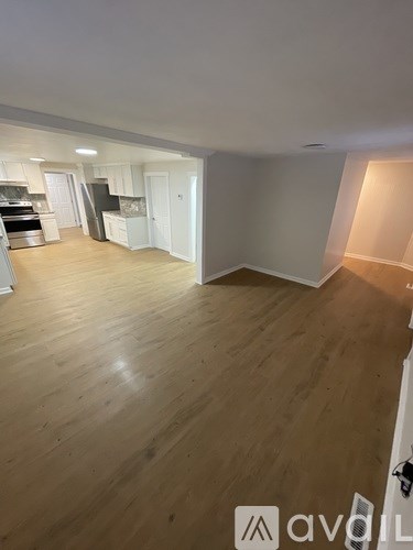 A room with wooden flooring and white walls.