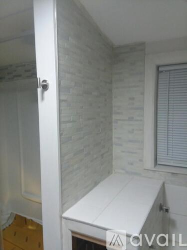 A white bathroom with a toilet and a window.