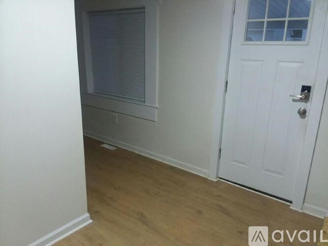 A white door with a window above it in a room with wooden flooring.