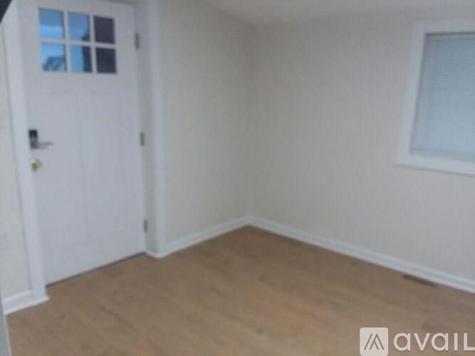 A room with a white door and a window.