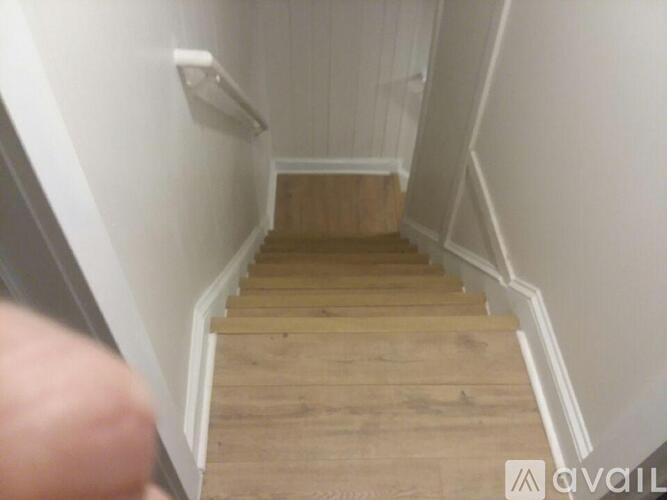 A staircase with wooden steps and white walls.